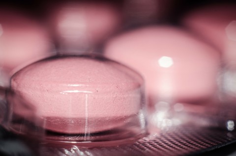 Pink medication tablet in clear inner packaging.