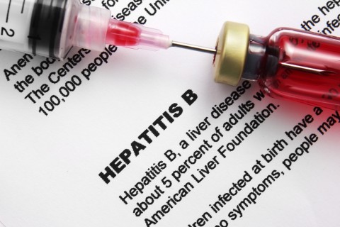 Paper that says "Hepatitis B" and a needle syringe going into a bottle on top of it. 