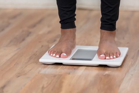 Bare feet standing on a digital scale.