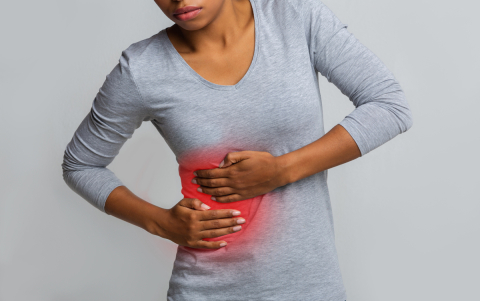 Close up of person in grey shirt holding the right side of their torso, red coloring in that section indicates pain.