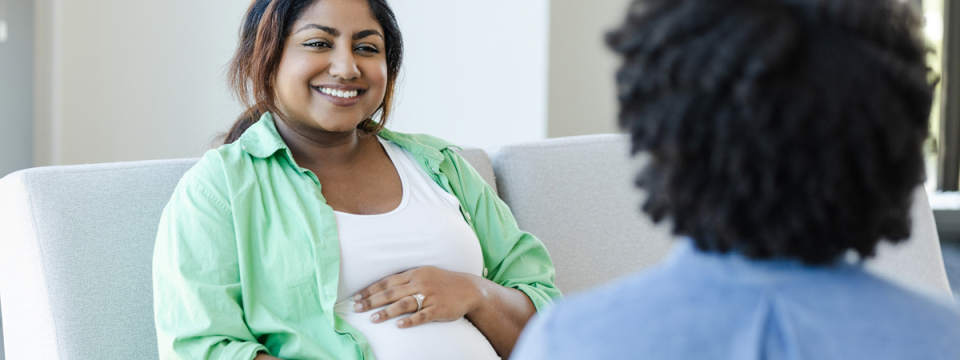 Pregnant person talking to a healthcare provider.