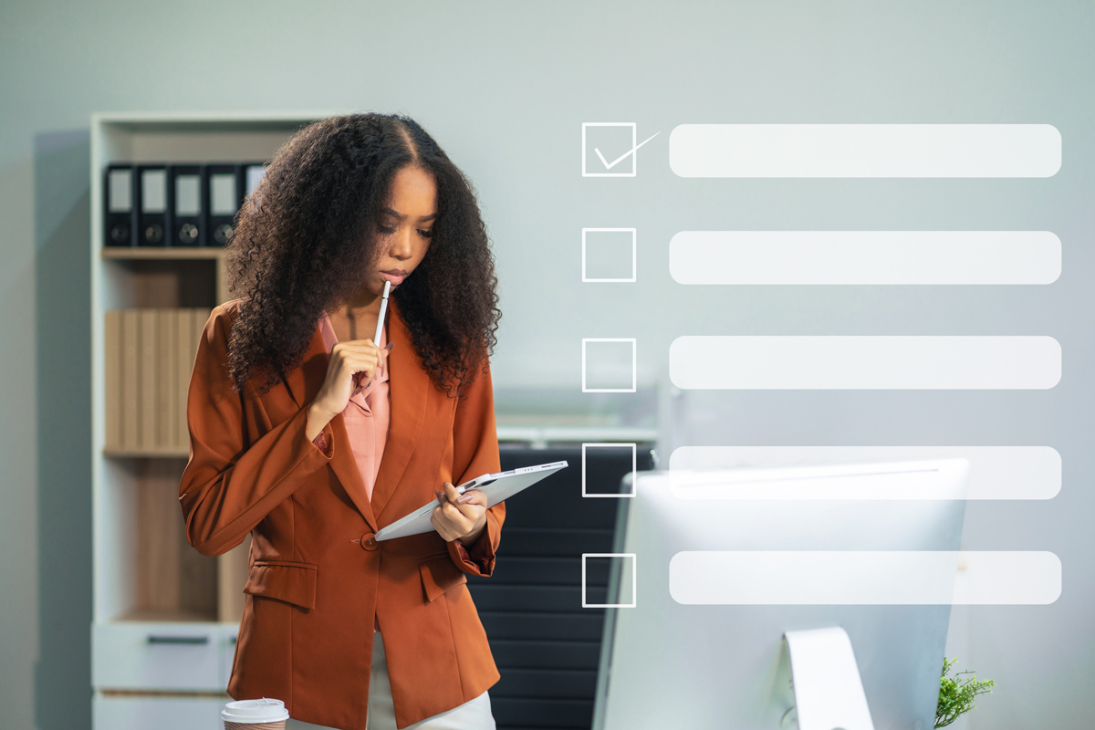 Woman looking at tablet in an office with a checklist superimposed on top of the image.