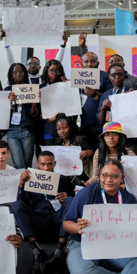 Grupo de personas con carteles que decían "Visa denegada".